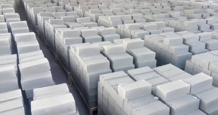 Rows of stacked white fly ash bricks pallets at DiXit FlyAsh Bricks and Precast Infra factory yard